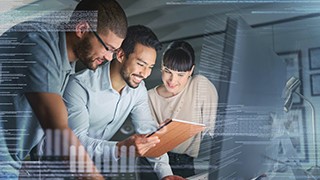 3 people, standing in front of a computer