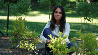 Girl sitting on the ground surrounded by plants