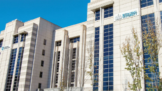 Image of the exterior of the IHS building with a Seton Hall logo and trees around it. 