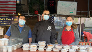 students standing and posing while giving out food