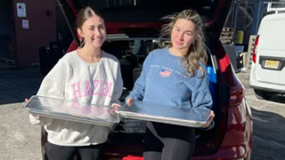 Alpha-Gamma-Delta volunteers Ella Gellemaro and Camryn Yarwood ready to deliver food to neighbors in need