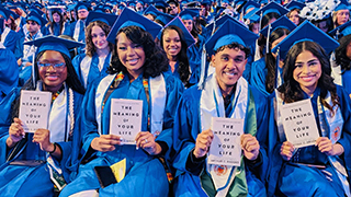 Graduates with Arthur Brooks' The Meaning of Your Life: Finding Purpose in an Age of Emptiness, gifted to the Class of 2026.