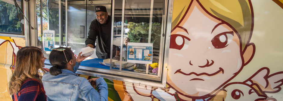 Student buying food at a food truck on campus. 