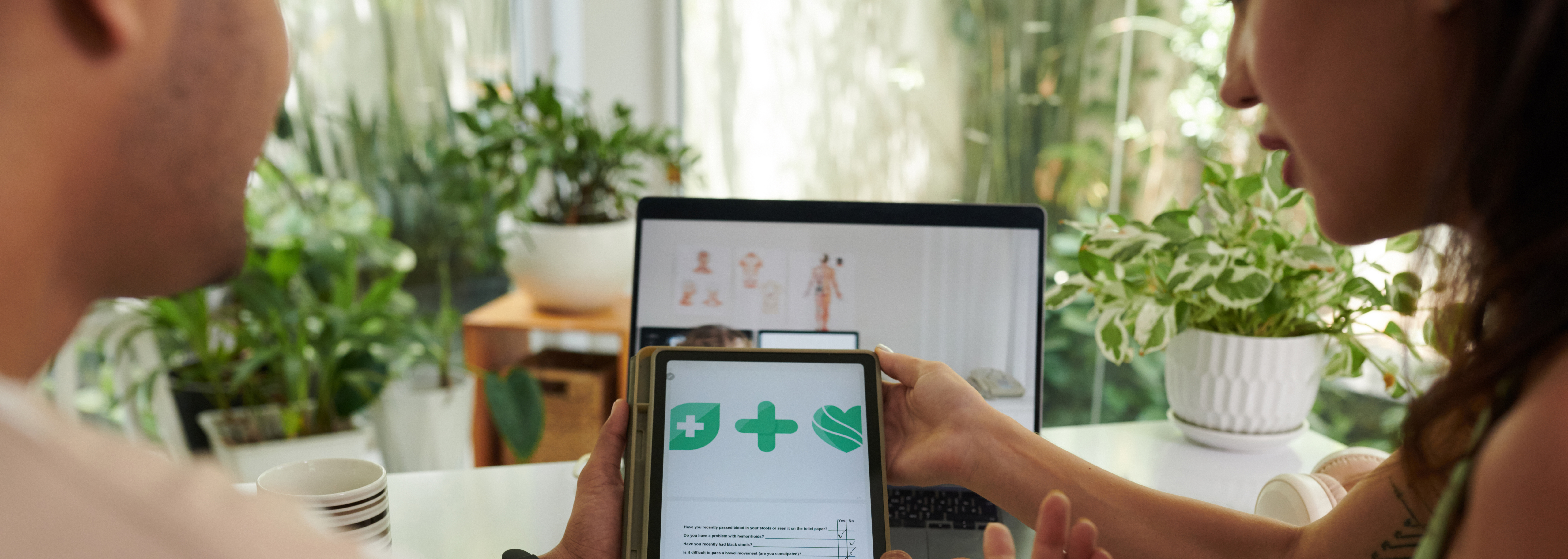 Two people looking over a medical chart and a medical simulation on two different screens. 