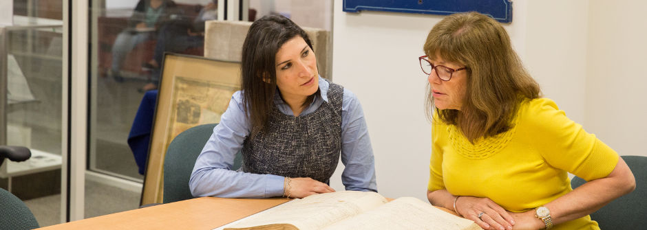 A History professor looking over a text with a student. 