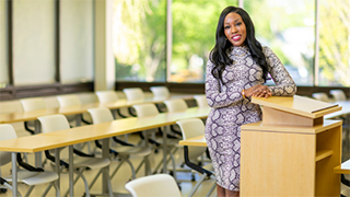 La'Tesha Sampson leaning on a classroom podium