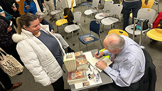 Roger Newman signing books at the event 