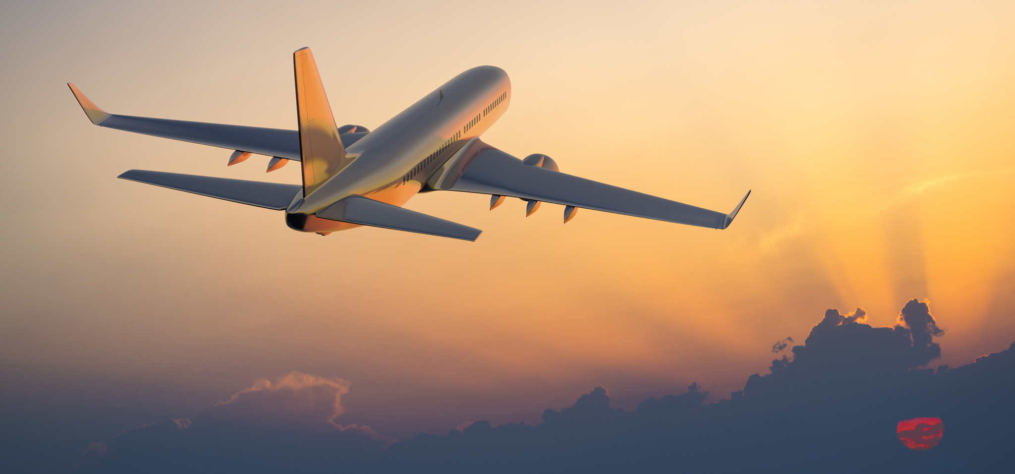 Image of a plane flying into the sunset 