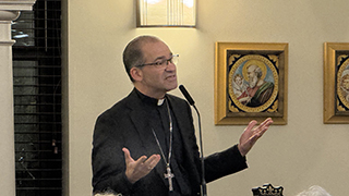 Image of a clergy member preaching wearing a cross 