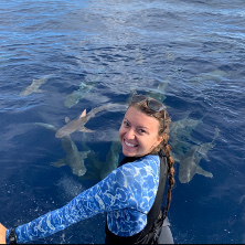 Andriana (Andy) Fragola on a boat with sharks in the water.