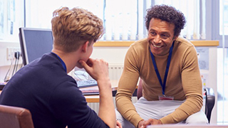 A student talking one on one with an advisor wearing a lanyard. 