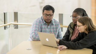 Students looking at table in McNulty. 