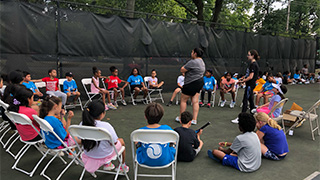 Instructor teaching a group of students sitting in a circle outside