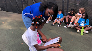 instructor helping child with instructions outside