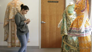 A student taking notes on an exhibit in the Walsh Gallery.