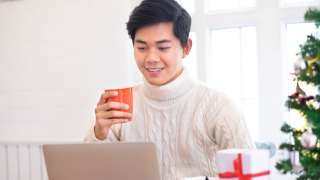 Young Adult working on a laptop at Christmastime.